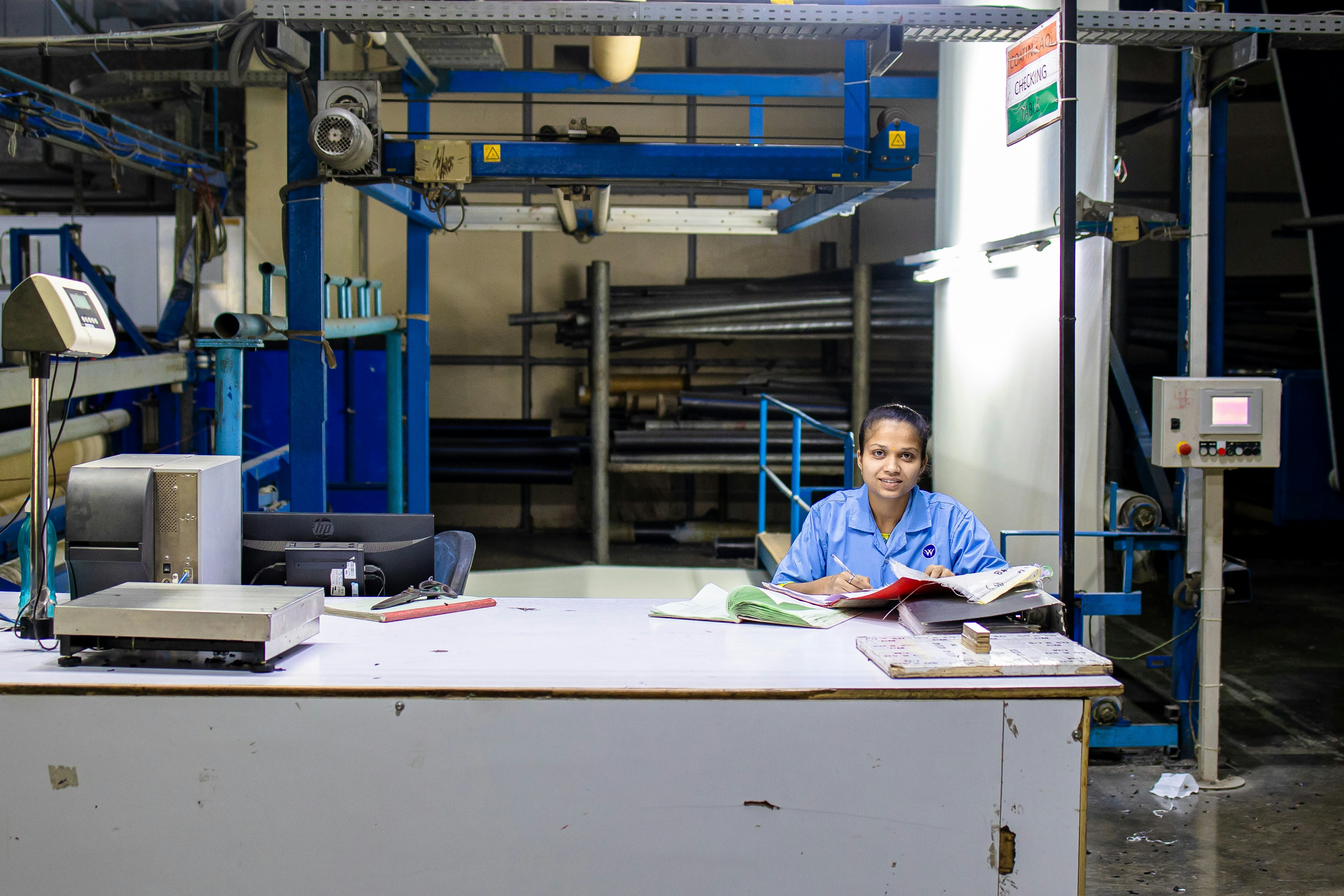 Factory worker at desk with paperwork in a manufacturing facility